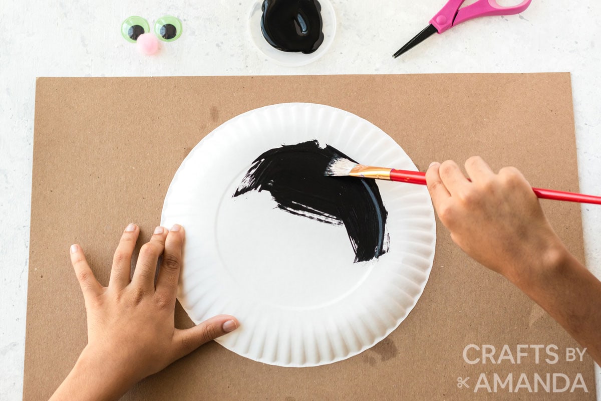 boy painting paper plate