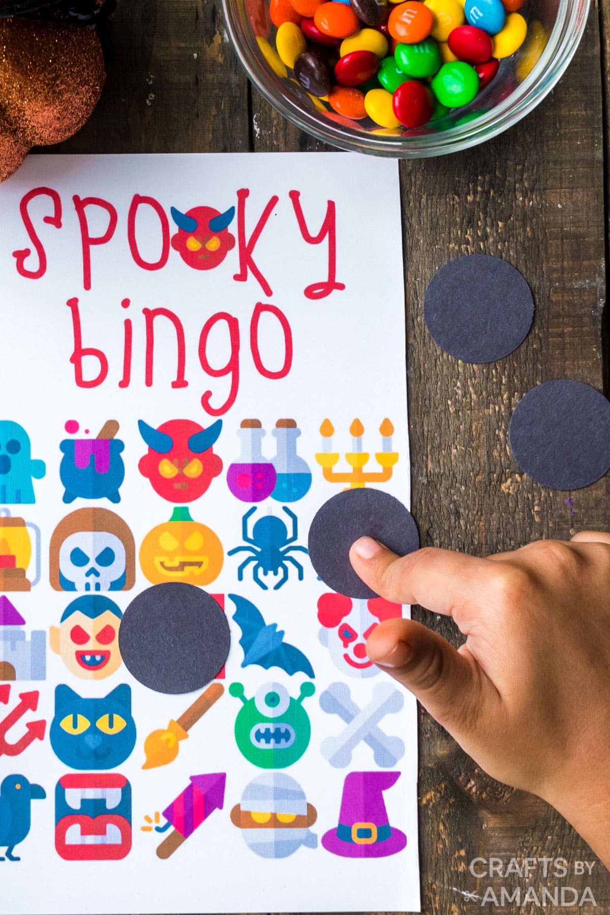 BOY PLACING MARKER ON HALLOWEEN BINGO