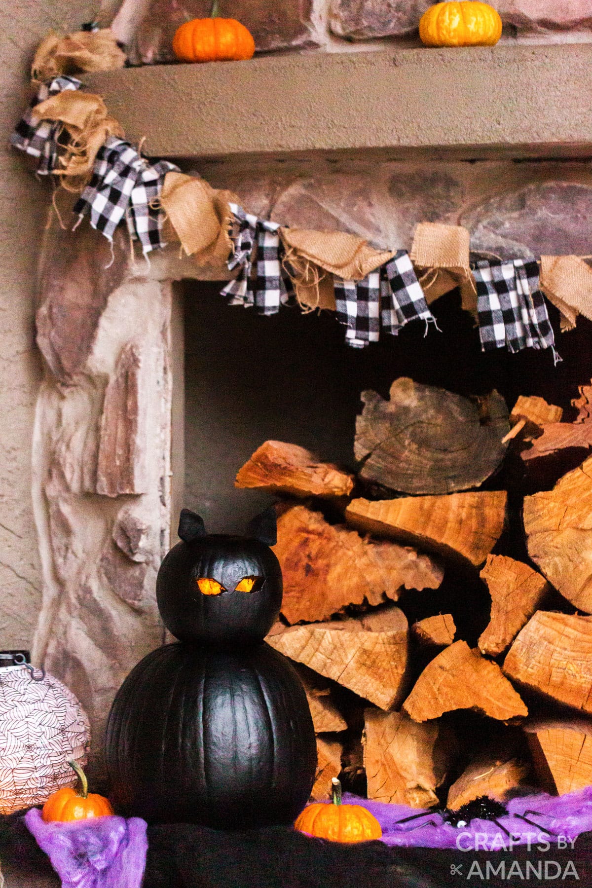 black cat pumpkin near fireplace