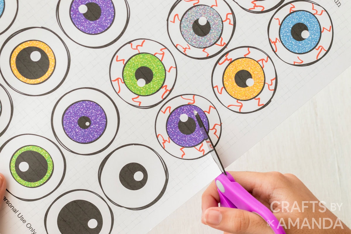 child cutting out picture of cartoon eyes