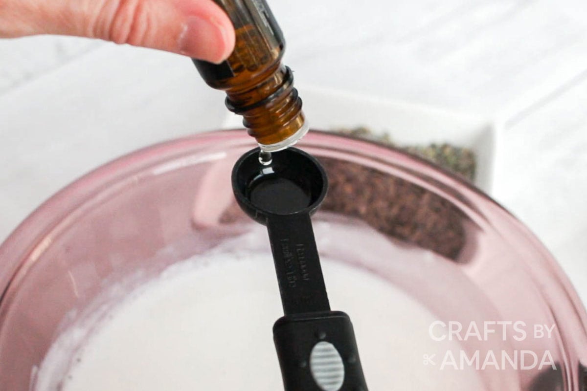 putting essential oil into a measuring spoon