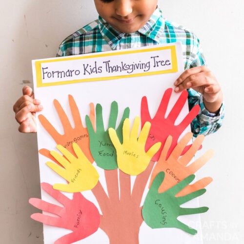 child holding thanksgiving handprint craft