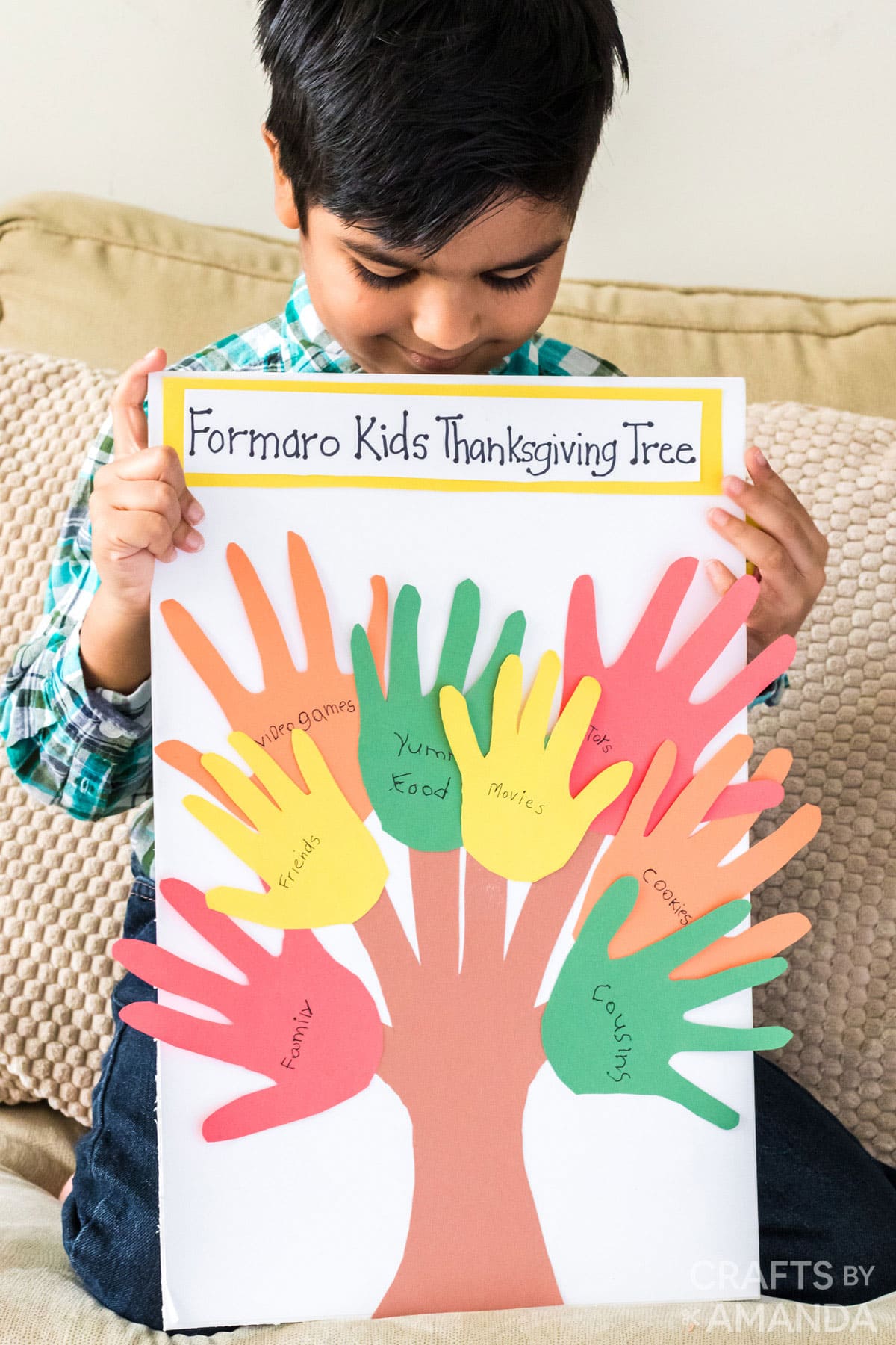 child holding thanksgiving handprint craft