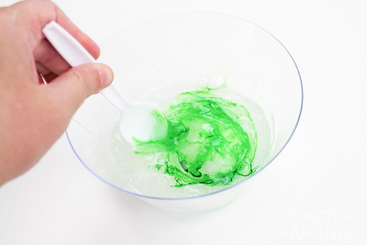 stirring green food coloring into slime