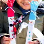 young boy holding paint stick snowmen