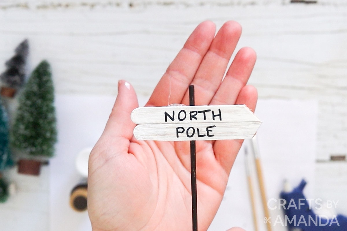 hand holding mini north pole sign