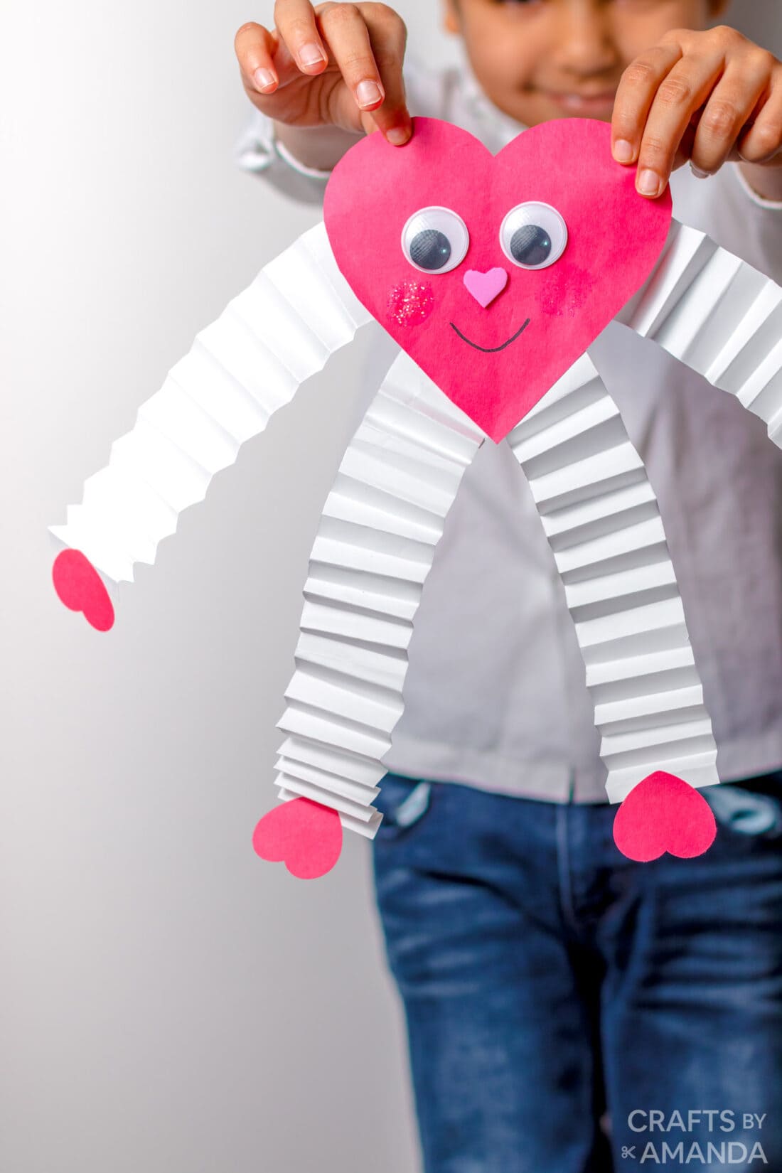 child holding paper valentine heart man with accordion arms
