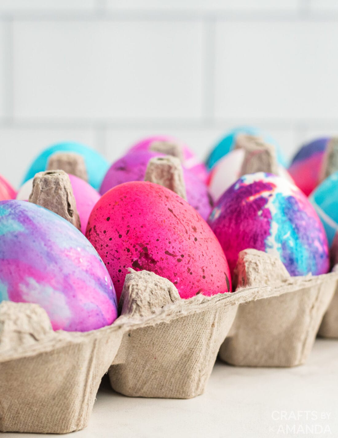 decorated easter eggs in an egg carton