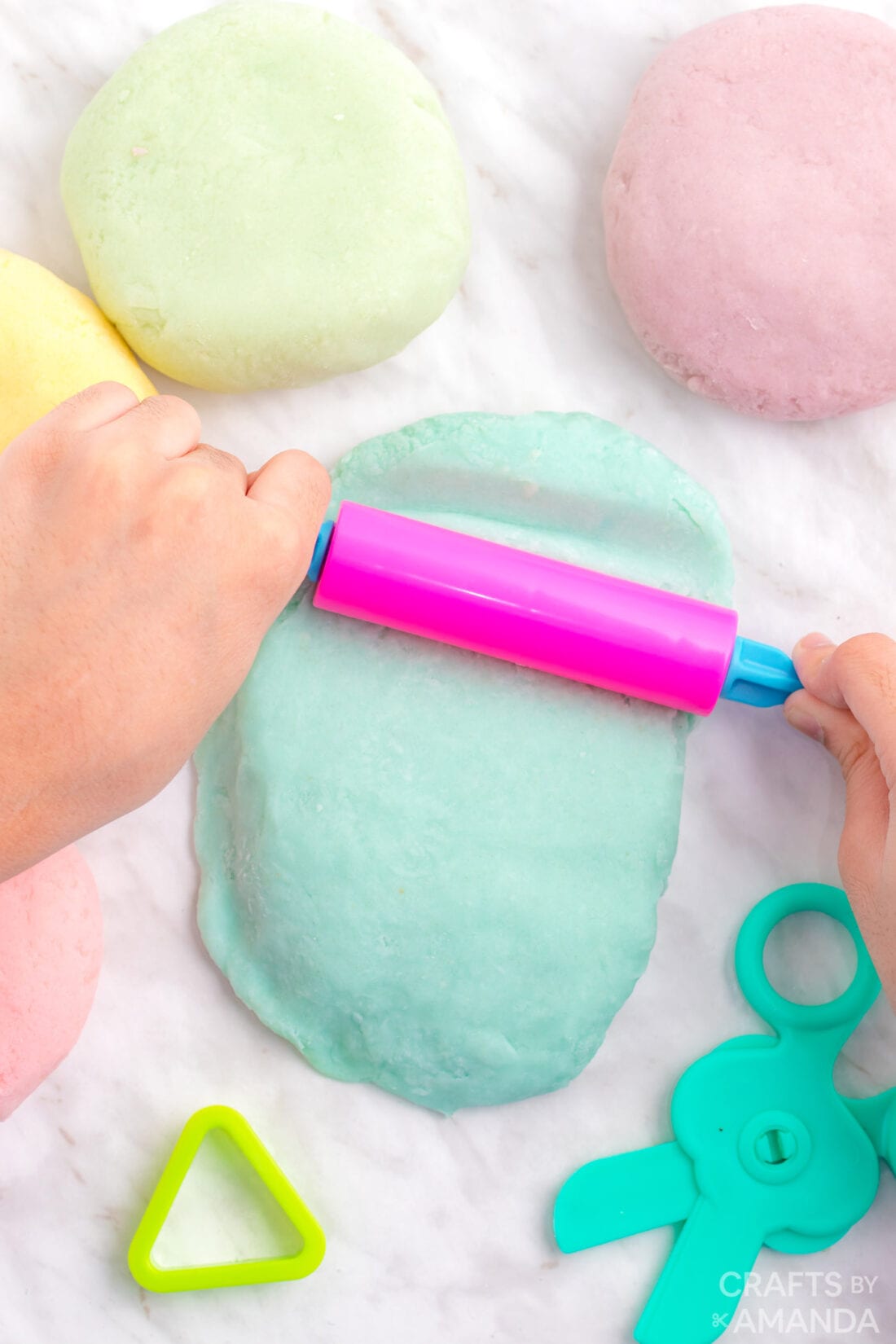child rolling out play dough