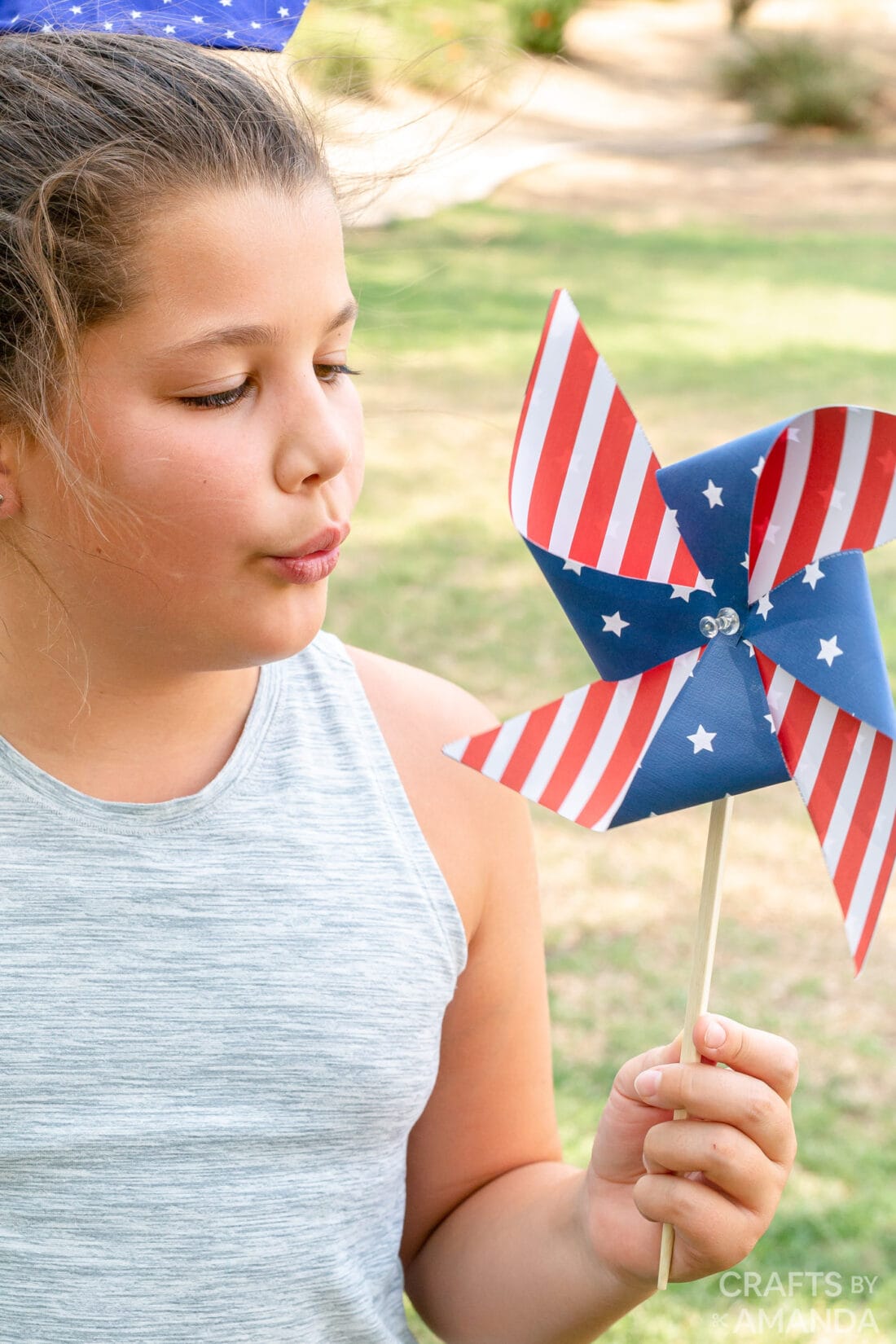 girl blowing on pinwheel