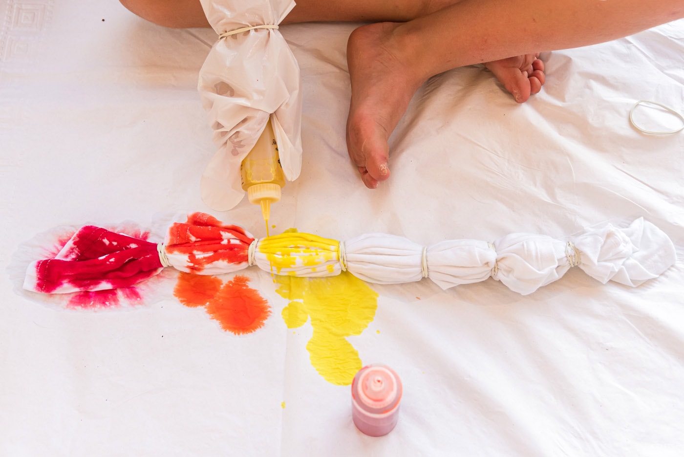 squeezing yellow dye onto white t shirt