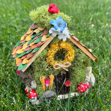 mini fairy house sitting in the grass